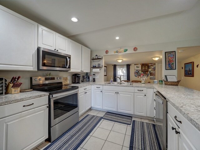 kitchen featuring stainless steel appliances, white cabinetry, light tile patterned floors, sink, and kitchen peninsula