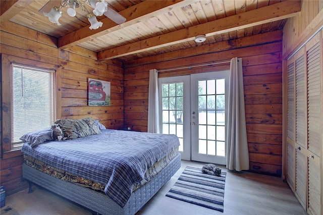 bedroom featuring french doors, light wood-type flooring, beam ceiling, wood ceiling, and ceiling fan