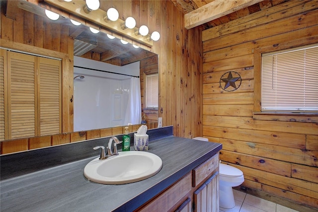 bathroom with curtained shower, vanity, tile patterned floors, wooden walls, and toilet