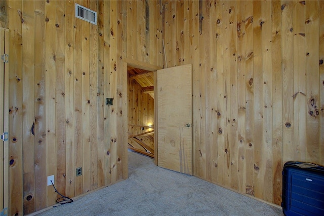 empty room with light colored carpet and wooden walls