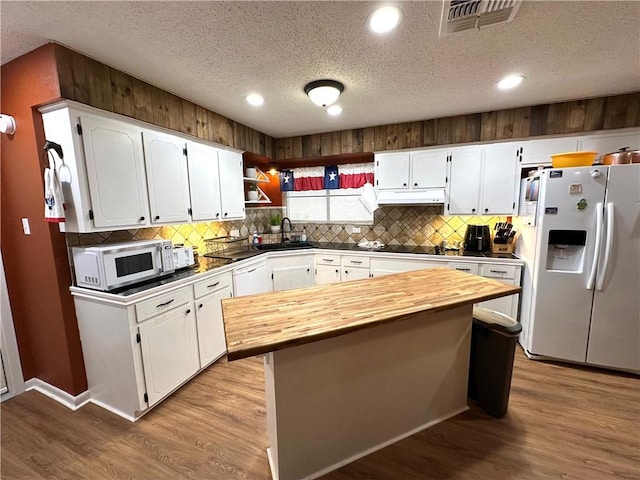 1510 Skyline Dr, Portland, TX 78374 - kitchen featuring white appliances, butcher block countertops, under cabinet range hood, a textured ceiling, and white cabinets
