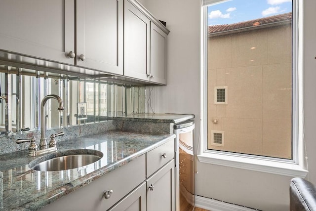 kitchen featuring sink and stone countertops