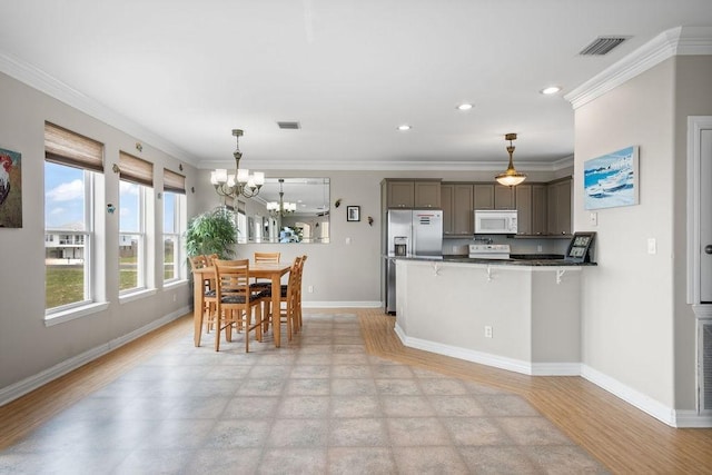 kitchen featuring crown molding, decorative light fixtures, light hardwood / wood-style flooring, stainless steel fridge, and kitchen peninsula