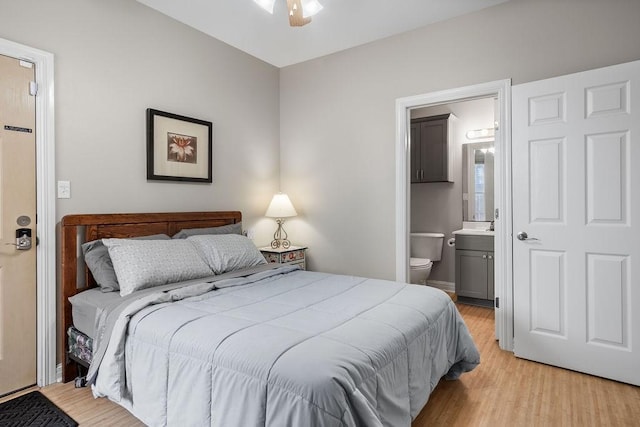 bedroom with ensuite bath and light hardwood / wood-style flooring