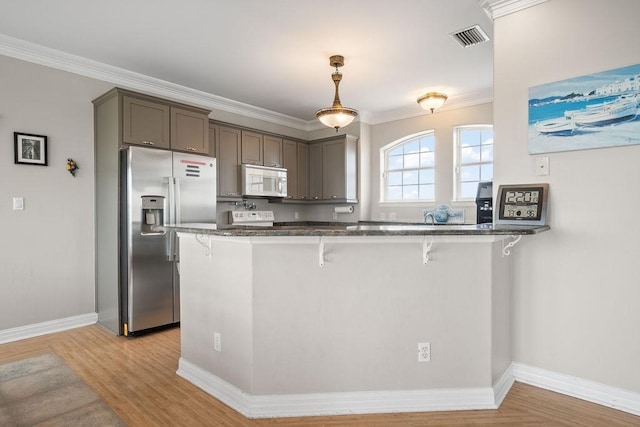 kitchen featuring crown molding, a breakfast bar area, kitchen peninsula, and stainless steel fridge with ice dispenser