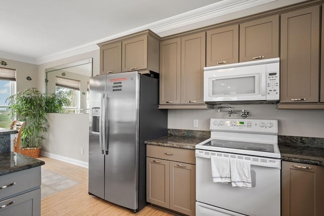 kitchen with white appliances, ornamental molding, light wood-type flooring, and dark stone counters