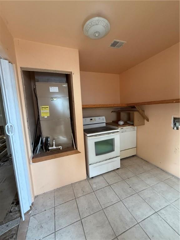 kitchen featuring light tile patterned floors, white appliances, and visible vents