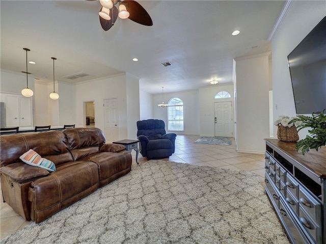 tiled living room with ceiling fan with notable chandelier and crown molding