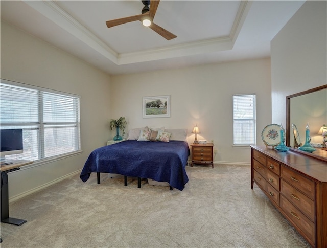 bedroom with a tray ceiling, multiple windows, light colored carpet, and ceiling fan