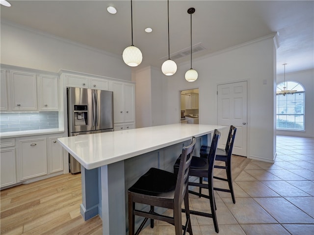 kitchen with a kitchen island, backsplash, and white cabinets