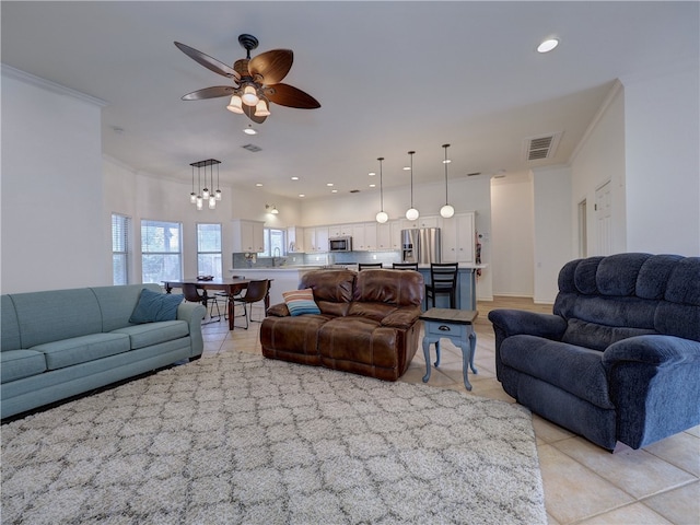 tiled living room featuring ceiling fan and ornamental molding