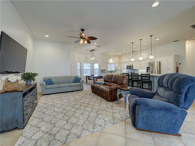 living room with light tile patterned floors, crown molding, and ceiling fan