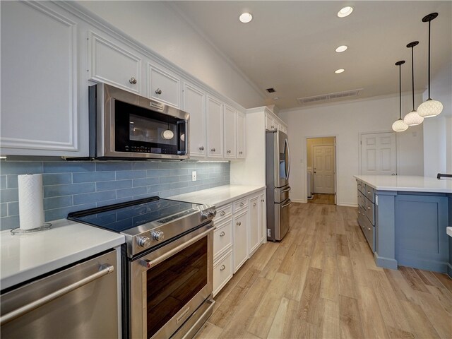 kitchen featuring stainless steel appliances, white cabinetry, pendant lighting, and light wood-type flooring