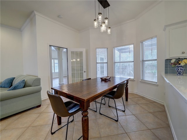 tiled dining room featuring a chandelier and ornamental molding