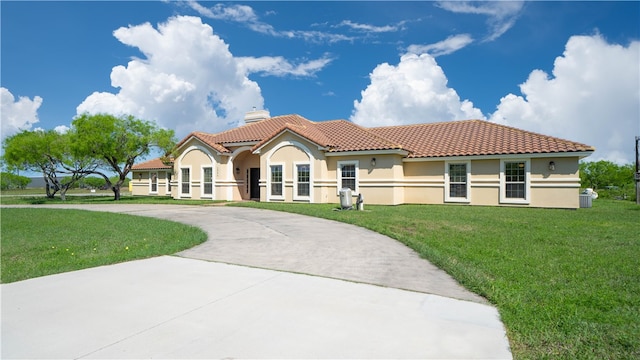 mediterranean / spanish home featuring a front lawn