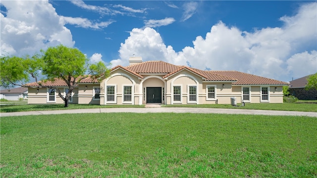 mediterranean / spanish home featuring a front lawn