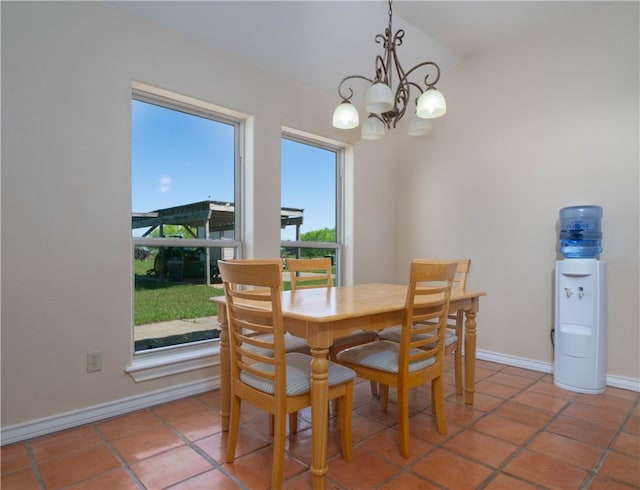 tiled dining room with a chandelier and a healthy amount of sunlight