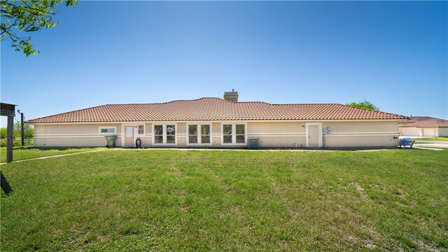 rear view of property featuring a lawn