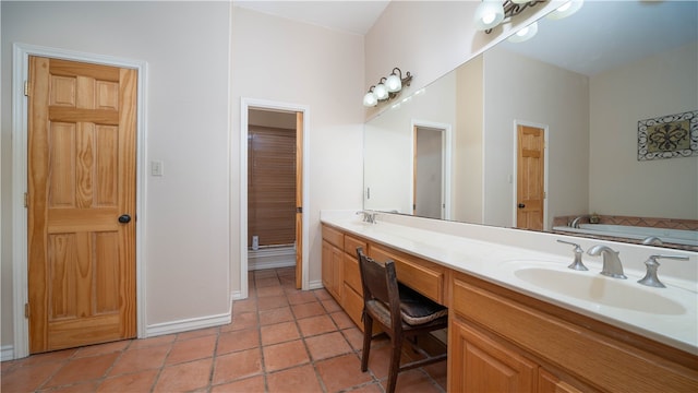 bathroom featuring tile patterned flooring, vanity, and a tub to relax in