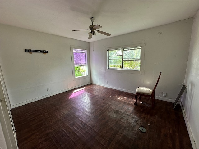 empty room with ceiling fan and dark hardwood / wood-style flooring