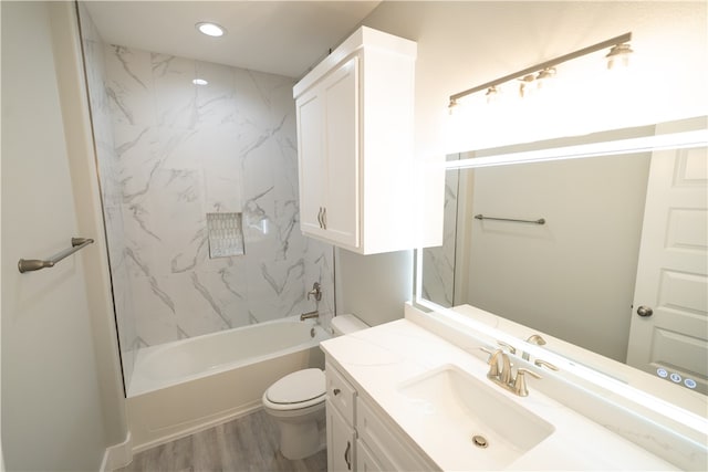 full bathroom with tiled shower / bath combo, toilet, wood-type flooring, and vanity