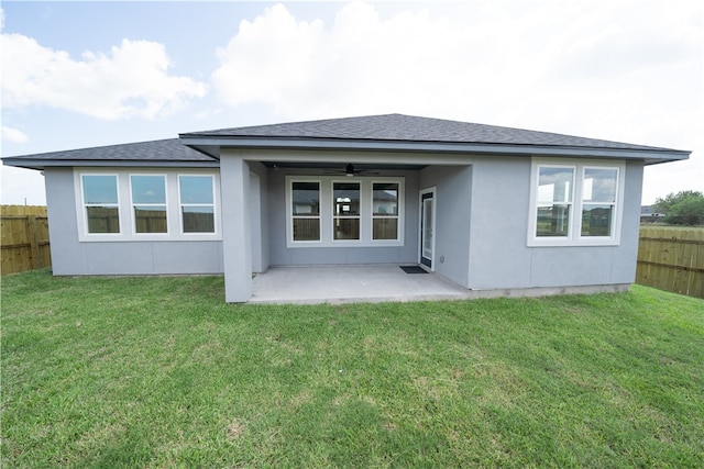 back of property with a lawn, a patio area, and ceiling fan