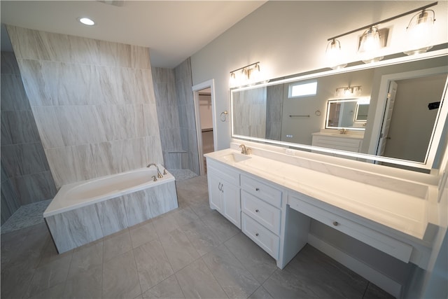 bathroom with tile patterned flooring, vanity, and a relaxing tiled tub