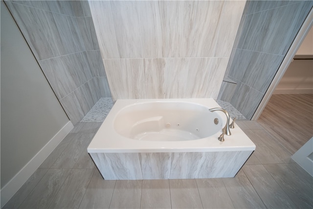 bathroom featuring tile walls and tiled tub