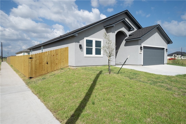 view of front of home with a garage and a front lawn