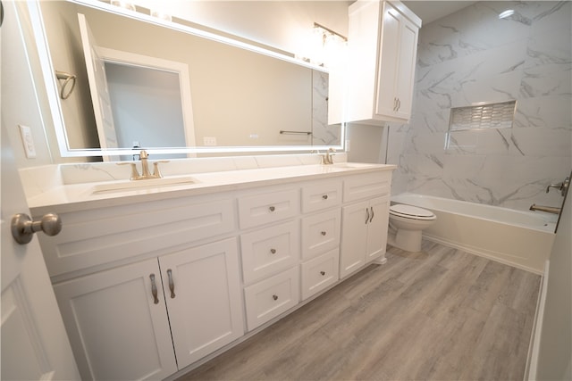 full bathroom featuring vanity, hardwood / wood-style flooring, toilet, and tiled shower / bath