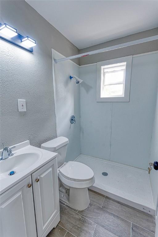 2221 Cleo St, Corpus Christi, TX 78405 - full bath with a shower, toilet, vanity, and a textured wall