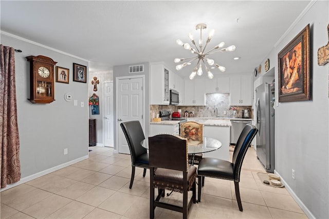 tiled dining space featuring sink, ornamental molding, and a chandelier