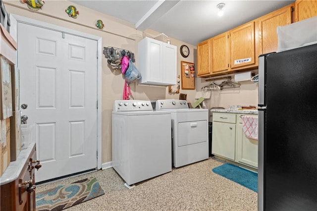 clothes washing area with cabinets and washer and dryer