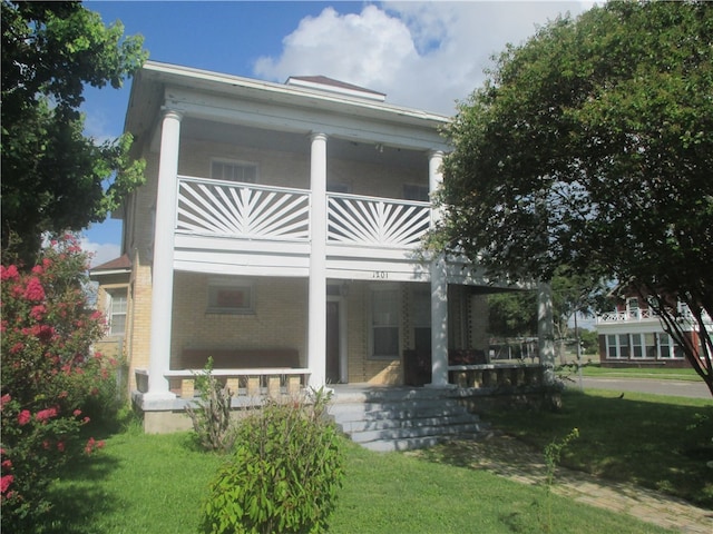 rear view of house featuring a lawn