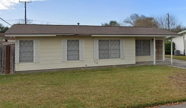 view of side of property with central AC unit and a lawn