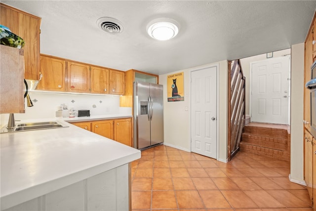 6845 Aswan Dr, Corpus Christi, TX 78412 - kitchen with stainless steel fridge with ice dispenser, light countertops, light tile patterned floors, and a textured ceiling