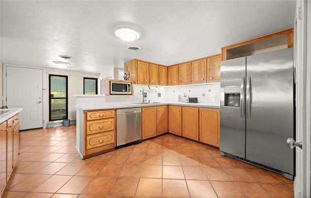 6845 Aswan Dr, Corpus Christi, TX 78412 - kitchen with appliances with stainless steel finishes, light countertops, light tile patterned floors, and a peninsula