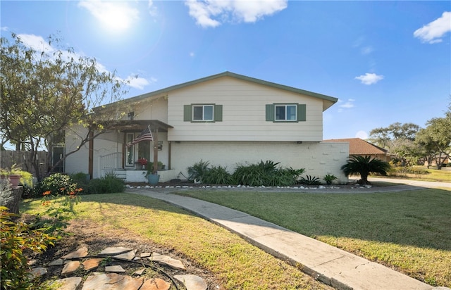 split level home with brick siding and a front yard