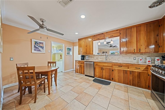 305 Circle Dr, Corpus Christi, TX 78412 - kitchen with appliances with stainless steel finishes, ceiling fan, a sink, brown cabinetry, and crown molding