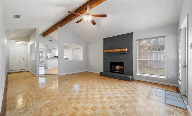 unfurnished living room featuring beamed ceiling, a fireplace, a textured ceiling, and light parquet floors