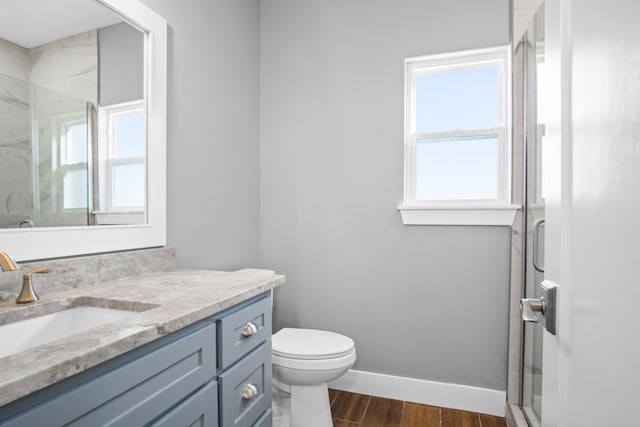 bathroom with an enclosed shower, vanity, hardwood / wood-style flooring, and toilet