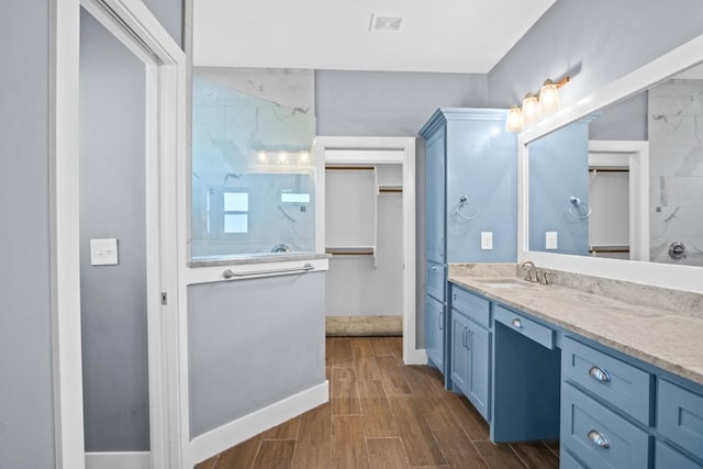 112 Dolphin Ct, Aransas Pass, TX 78336 - bathroom featuring vanity, baseboards, wood finished floors, and a shower