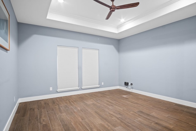 spare room featuring hardwood / wood-style floors, ceiling fan, a raised ceiling, and crown molding