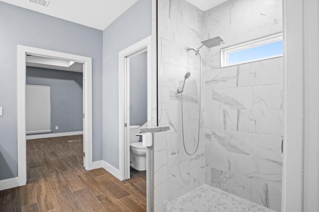 112 Dolphin Ct, Aransas Pass, TX 78336 - bathroom featuring toilet, a marble finish shower, wood finished floors, and baseboards