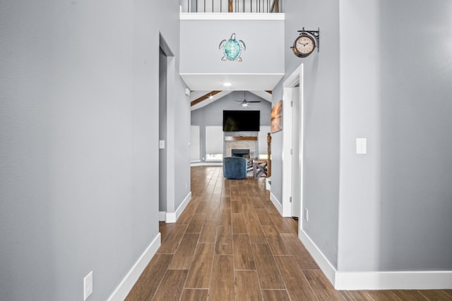 hall with hardwood / wood-style flooring and high vaulted ceiling