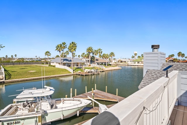 view of dock with a yard and a water view