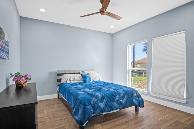 bedroom with dark hardwood / wood-style flooring and ceiling fan