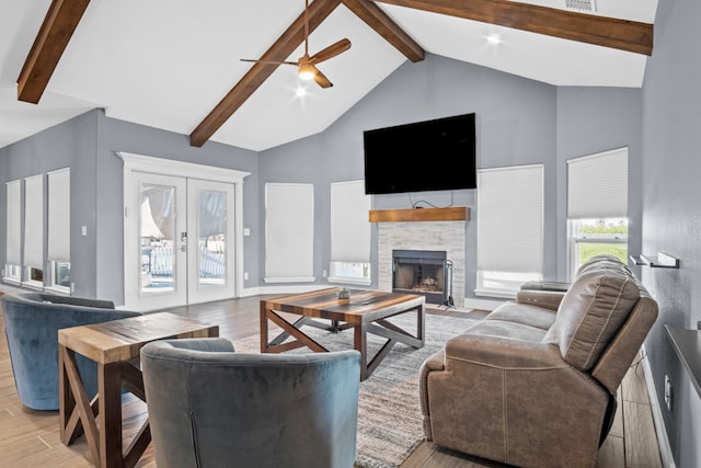 living room featuring french doors, a fireplace, beam ceiling, high vaulted ceiling, and light hardwood / wood-style floors