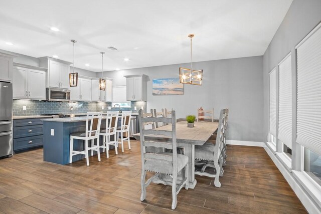 112 Dolphin Ct, Aransas Pass, TX 78336 - dining space featuring a chandelier, dark wood-style floors, recessed lighting, and baseboards