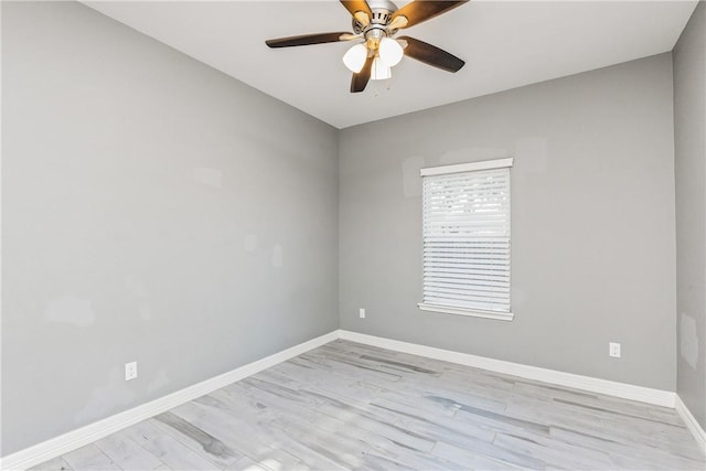 empty room featuring light wood finished floors, baseboards, and a ceiling fan